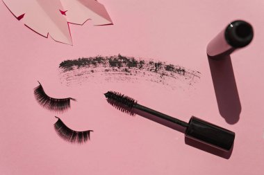 Black false lashes strips, mascara on pink background with paper clipart