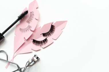 Black false lashes strips, mascara, curler  on white background  clipart