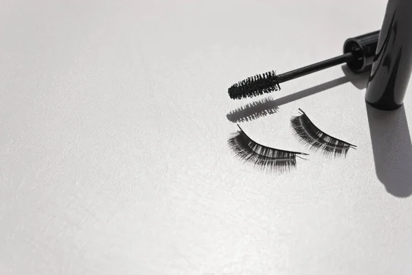 Black false lashes strips with mascara on white background
