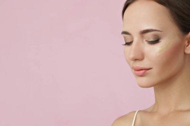 Kozmetik temel cilt üzerinde pembe bir arka plan üzerine olan kadın 