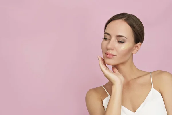 Jeune Femme Avec Fond Teint Cosmétique Sur Fond Rose — Photo