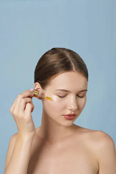 Portrait Young Woman Applying Serum Her Face Blue Background — Stock Photo, Image