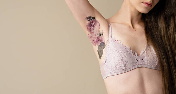 cropped shot of woman showing underarm with flower picture 