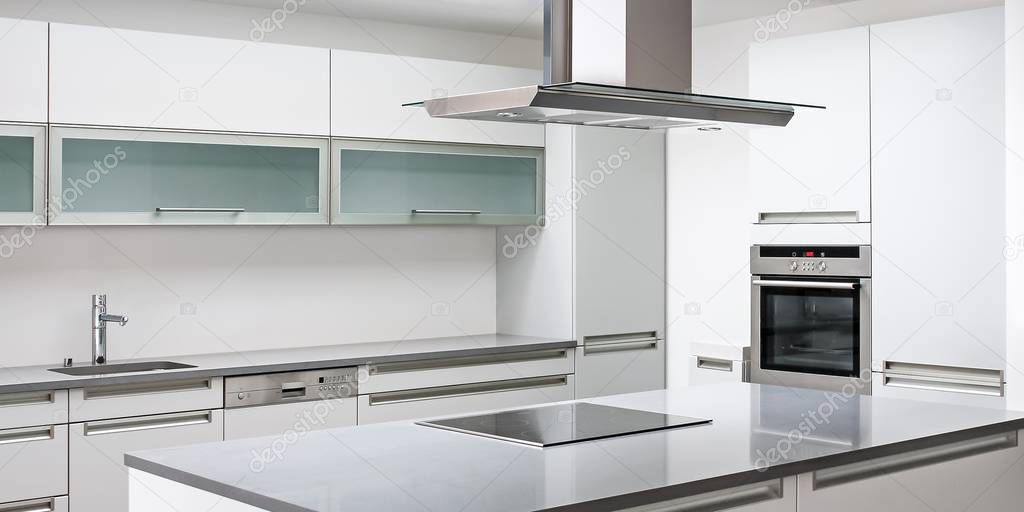 Minimalist modern kitchen with range hood, stove, microwave oven and sink, Luxurious modern kitchen with stainless steel appliances
