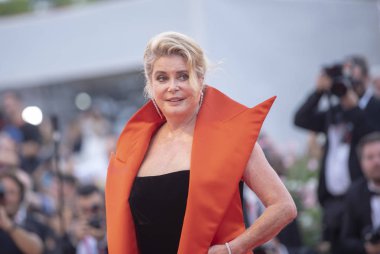 Catherine Deneuve kırmızı halıda yürüyor. 