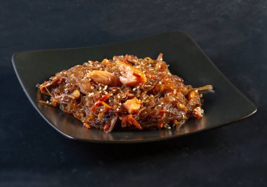 Siyah arka planda siyah seramik tabakta Japon mutfağı soba vermicelli. Geleneksel karabuğday ezmesi, mantarlı ve tavuklu akşam yemeği, salona taşınmak için hazırlandı. Doğu Restoranı.