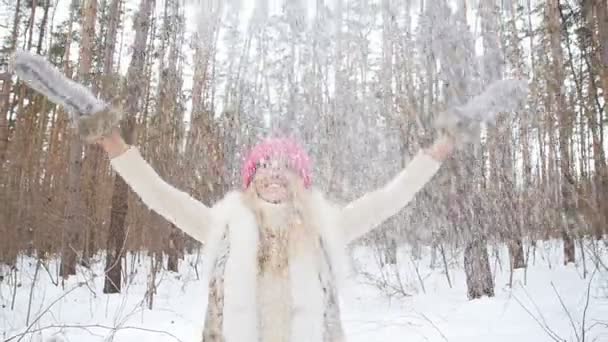 Junge glückliche lächelnde Frau wirft Schnee — Stockvideo