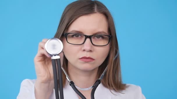 Женщина-врач со стетоскопом слушает — стоковое видео