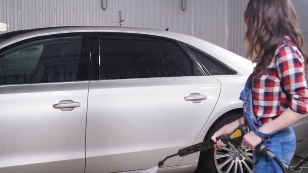 Vrouw wassen auto met hogedruk blaster — Stockvideo