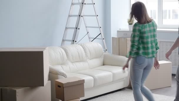 Leende unga paret flyttar till en ny lägenhet — Stockvideo