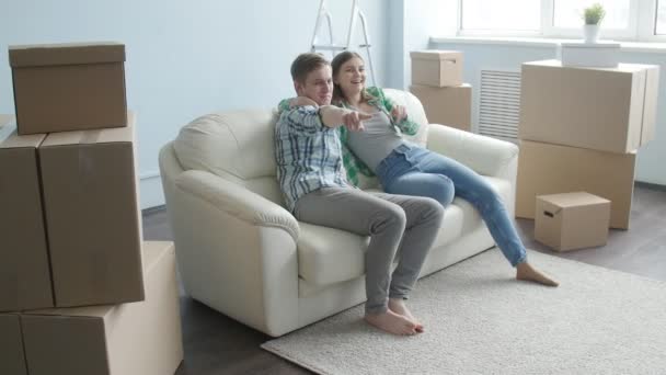Sonriente joven pareja se muda a un nuevo apartamento — Vídeo de stock