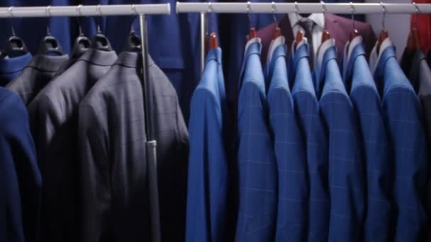 Mężczyźni garnitury i marynarki wiszące w sklepie odzieżowym — Wideo stockowe