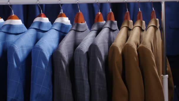 Hombres trajes y chaquetas colgando en una tienda de ropa — Vídeos de Stock