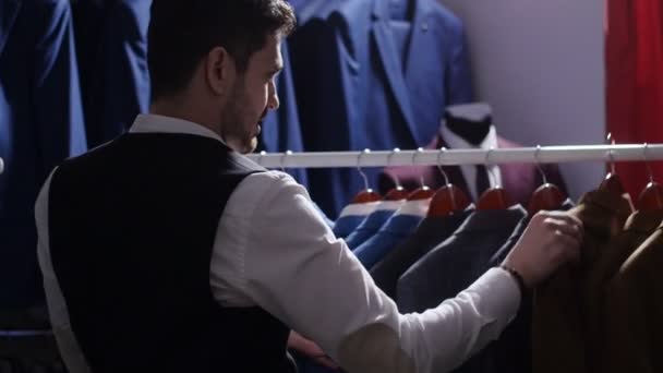 Junger Mann wählt klassischen Anzug im Anzug-Geschäft — Stockvideo