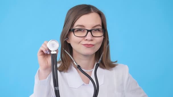 Eine junge Ärztin mit Stethoskop hört zu — Stockvideo