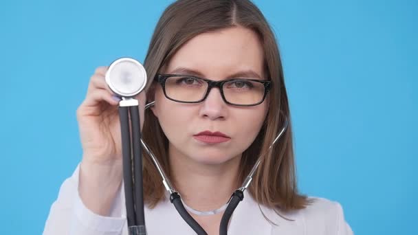 Una joven doctora con un estetoscopio escuchando — Vídeos de Stock