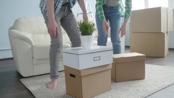 Feliz joven pareja con cajas de cartón se traslada a nuevo apartamento — Vídeos de Stock