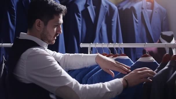 Uomo che sceglie abito da lavoro al negozio di abbigliamento uomo — Video Stock