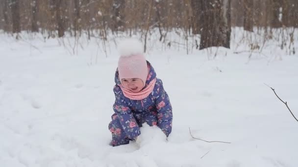 Meisje speelt met de sneeuw in het park — Stockvideo