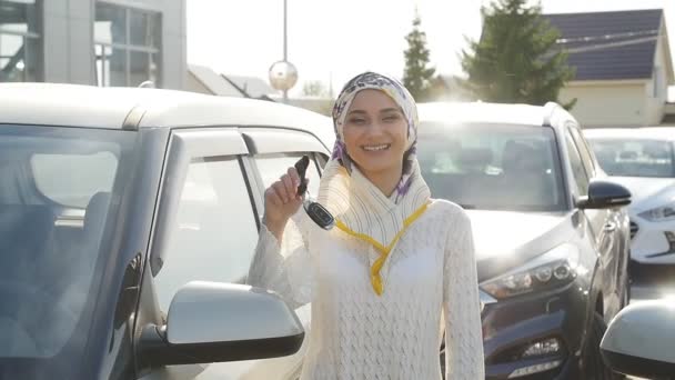 Muslim woman in hijab with car key outdoors — Stock Video