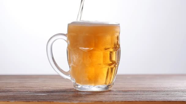 Cerveja derramada em vidro sobre fundo branco — Vídeo de Stock