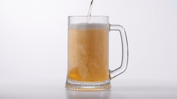 Cerveza vertida en vidrio sobre fondo blanco — Vídeos de Stock