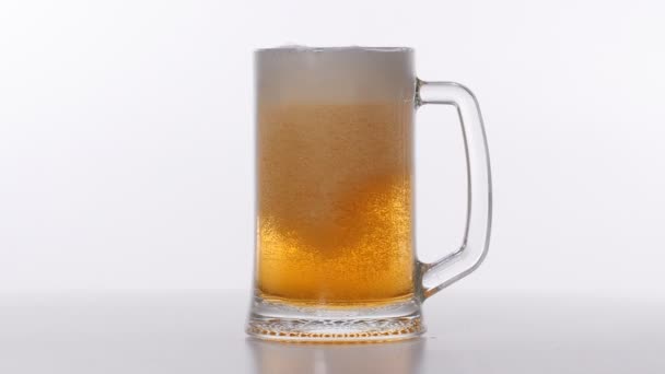 Bier in Glas auf weißem Hintergrund gegossen — Stockvideo