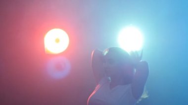 Genç modern stil dansçı duman ve ışıkları karanlık bir arka plan üzerinde