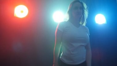 Genç modern stil dansçı duman ve ışıkları karanlık bir arka plan üzerinde