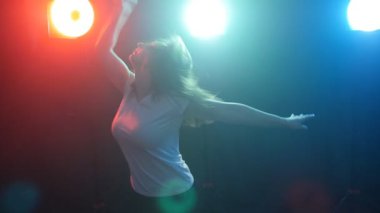 Genç modern stil dansçı duman ve ışıkları karanlık bir arka plan üzerinde