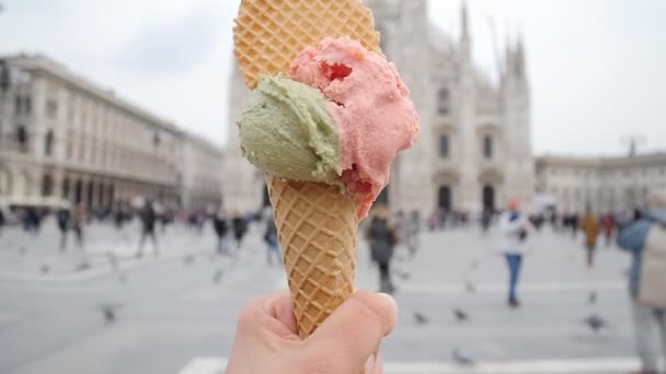 Olasz fagylalt kúpot tartott a kezében, a háttérben a Piazza del Duomo, Milánó — Stock videók