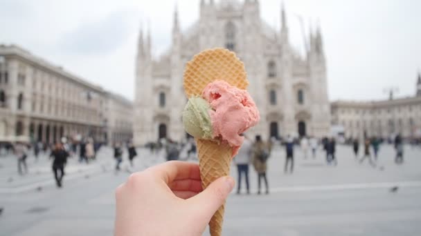 Italian ice cream cone held in hand on the background of Piazza del Duomo in Milano — Stock Video