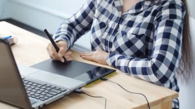 Dijital çizim tablet ve kalem ile bir bilgisayarda çalışan kadın grafik tasarımcı
