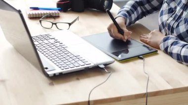 Dijital çizim tablet ve kalem ile bir bilgisayarda çalışan kadın grafik tasarımcı
