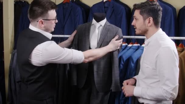 Muž si kupuje oblek v obchodě. — Stock video