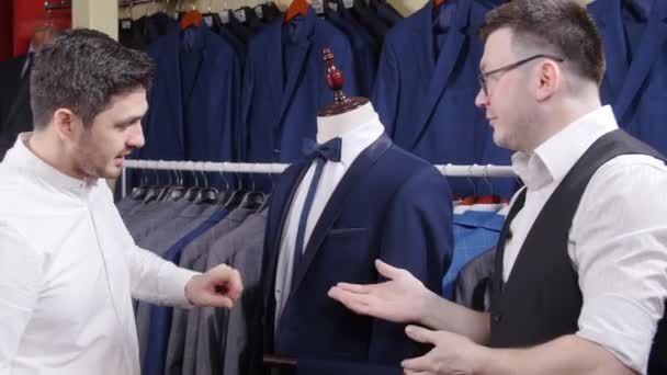 Чоловік купує костюм у магазині — стокове відео