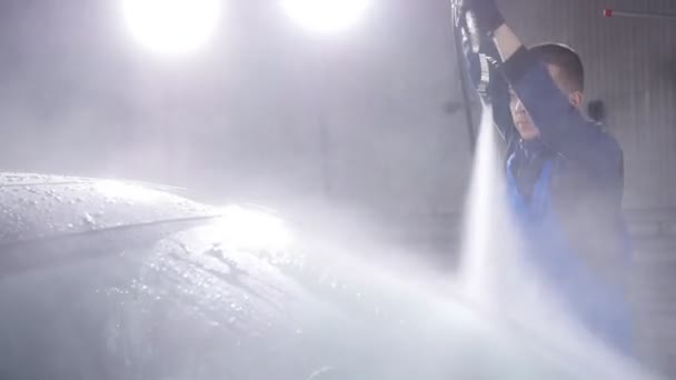 Man wassen auto onder hoge druk water — Stockvideo