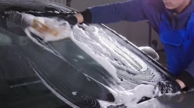 Adam çalışan çamaşır araba sünger bir araba yıkama istasyonu ile