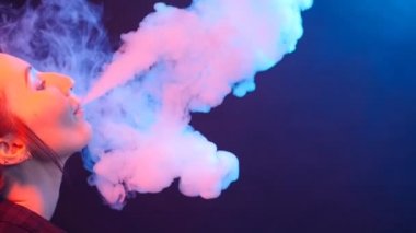 Glamour baştan çıkarıcı muhteşem bir esmer kadın sigara elektronik sigara neon renkli stüdyoda ışık portresi