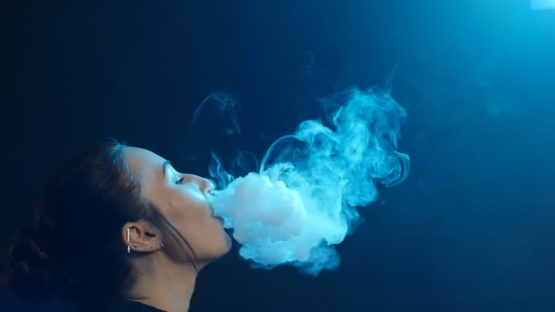 Retrato de glamour sedutora linda morena fumando cigarro eletrônico em luz de cor de néon no estúdio — Vídeo de Stock