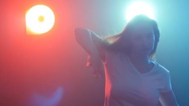 Genç kadın bir disko renk ışık altında dans