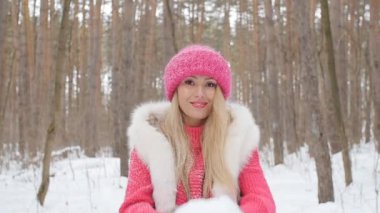 Genç kadın kar kış ormanın içinde güzel bir gülümseme ile atar