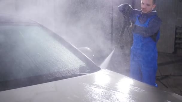 Mann wäscht Auto unter hohem Wasserdruck in Innenräumen — Stockvideo