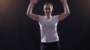 Genç kadın bir siyah arka plan üzerinde dans