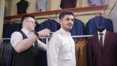 Adam bir takım elbise giyim mağazası başka bir denemede yardımcı olur.