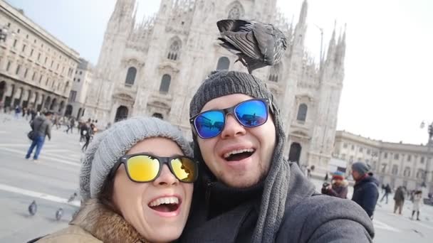 Счастливые туристы делают автопортрет с телефоном перед кафедральным собором Дуомо в Милане. Концепция зимнего туризма — стоковое видео