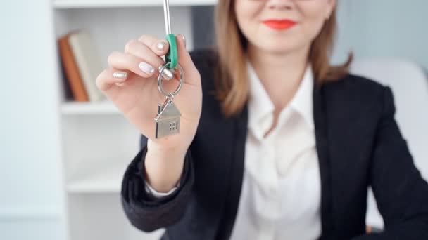Улыбающаяся молодая женщина-риэлтор передает ключи от новой недвижимости — стоковое видео