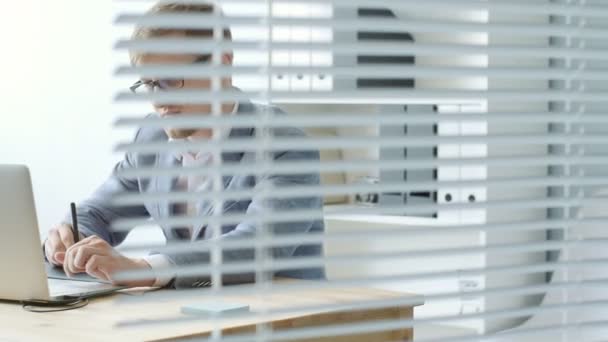 Junger Mann mit Brille arbeitet an einem Grafik-Tablet — Stockvideo