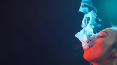 Renkli duman ile parlak ışıklar genç kadın. Sigara elektronik sigara ve vaping kavramı