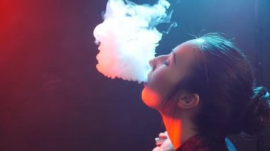 Renkli duman ile parlak ışıklar genç kadın. Sigara elektronik sigara kavramı